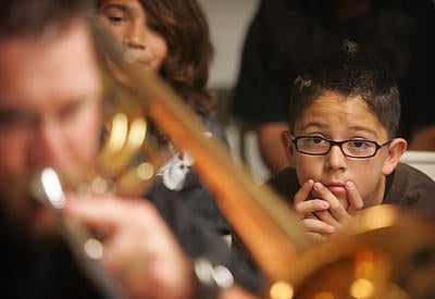 students watching a musician play a trombone