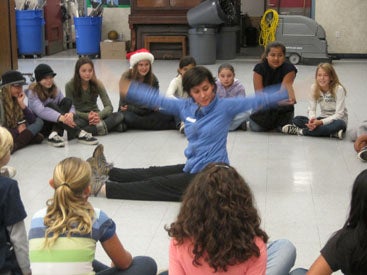 dance instructor sitting in the middle of a circle of students
