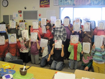 group photo of students holding up art projects