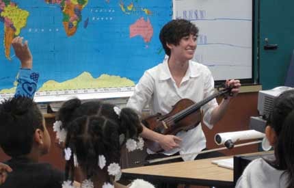 students watching a musician demonstrate the fiddle