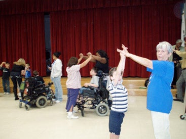 students in wheelchairs learning a dance