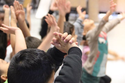 closeup of a group of students raising their hands