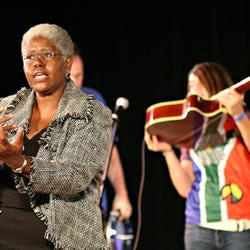storyteller gesturing with musicians in the background